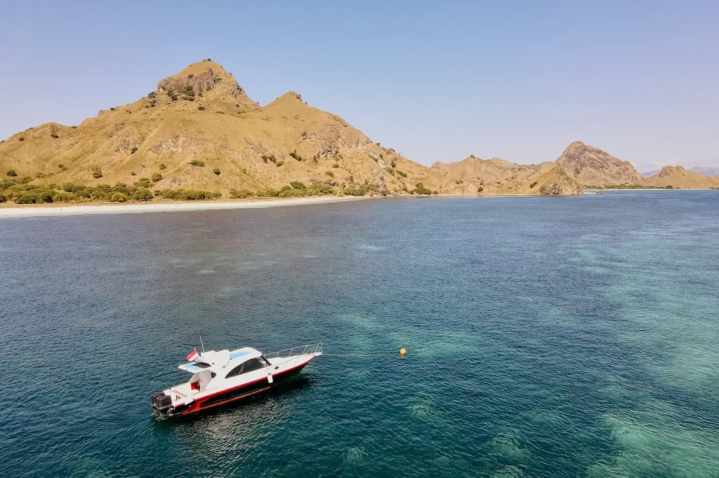 Athar boat docked near Pink Beach as guests snorkel nearby.