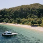 Speedboat Athar docked along the white sands of Sture Beach.