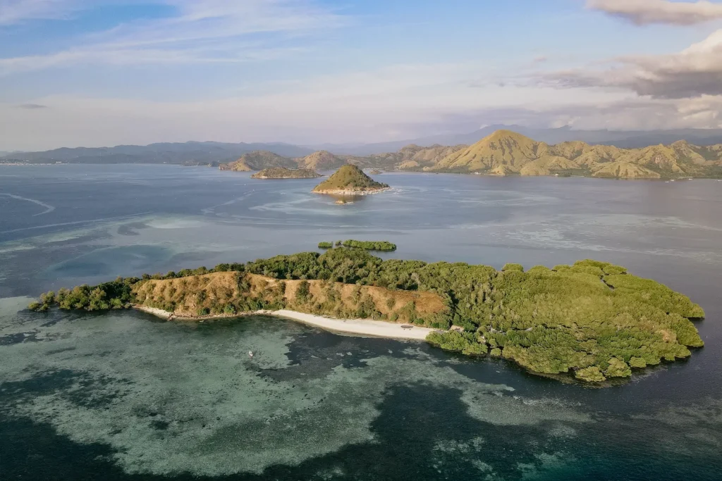 Drone view capturing Bangkau's coral-rich coastline and turquoise water.