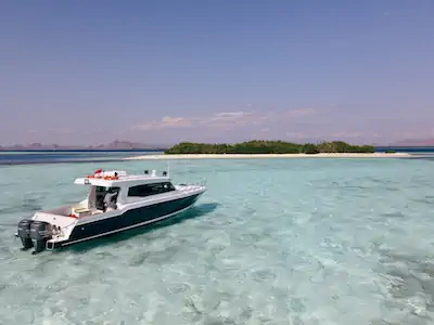 Our boat Como anchored near a white sand beach in Komodo