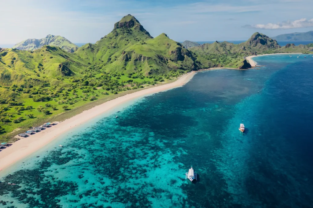 View of colorful coral reef visible beneath clear waters of Pink Beach.