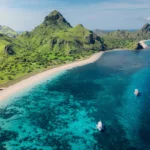 View of colorful coral reef visible beneath clear waters of Pink Beach.