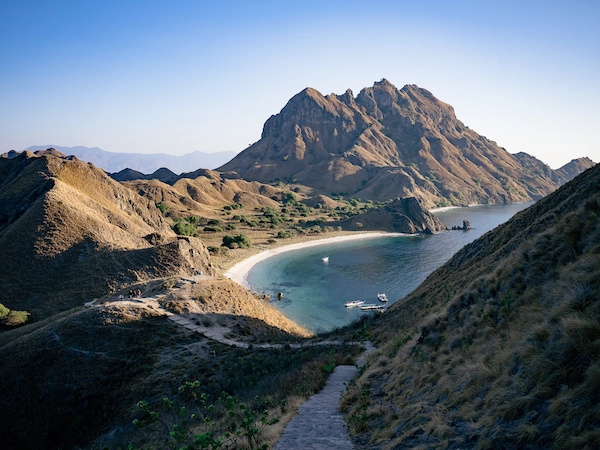 Iconic Padar Island hill with stairway path and white sand beach below