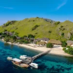 Sebayur Island dock near Komodo Resort with white sand beach, boats, and coral-rich waters