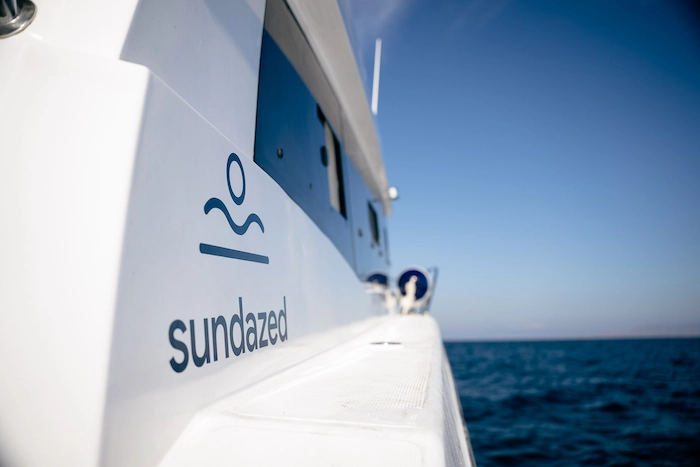 Side view of Sundazed speedboat Como cruising through the sea for labuan bajo destinations with logo visible