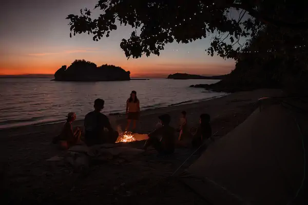 Family photo of the Sundazed crew at Sture Beach with Como boat in the background discussing labuan bajo destinations