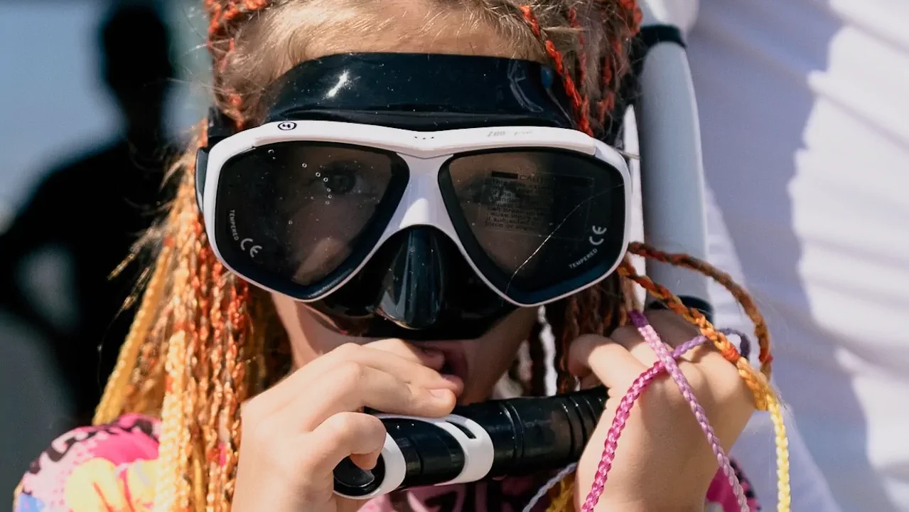Young girl adjusting her snorkel mask, excited to jump in for a komodo snorkeling trip